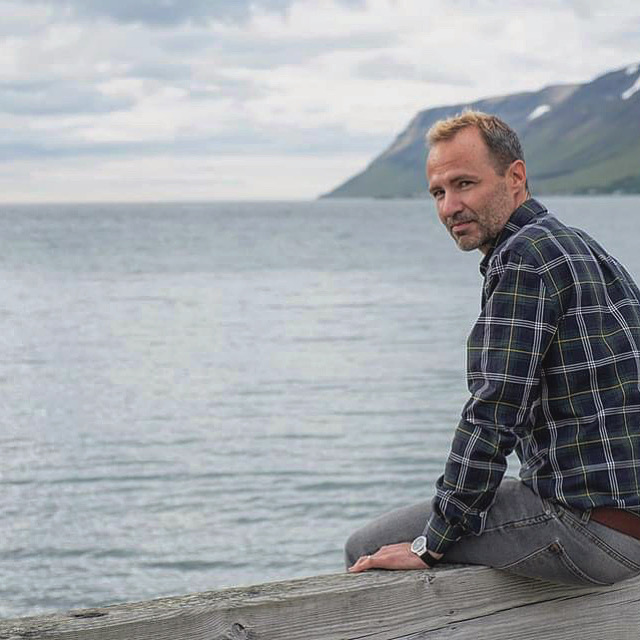 Hombre sentado en embarcadero Islandia